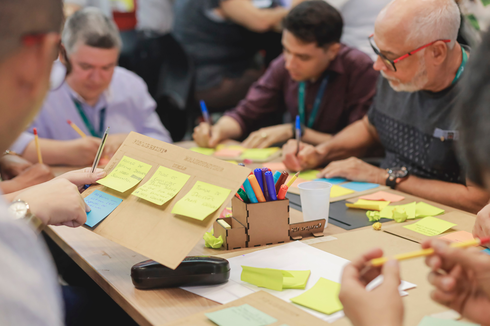 Grupo diverso em atividade colaborativa com post-its e canetas